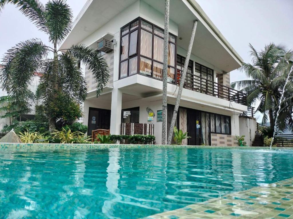 a house with a swimming pool in front of a house at Casa Herminia Baler in Baler