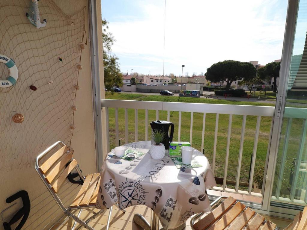 a table and chairs on a balcony with a view at Appartement Le Grau-du-Roi, 2 pièces, 4 personnes - FR-1-307-182 in Le Grau-du-Roi