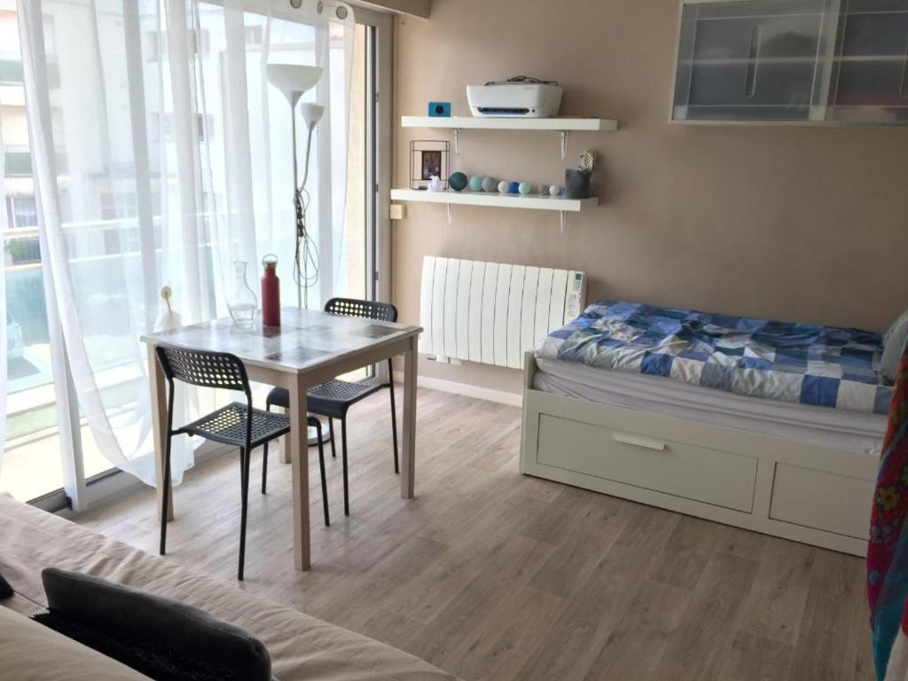 une chambre avec un lit, une table et des chaises dans l'établissement Studio 20m² lumineux avec balcon - Cœur de Berck Plage, proche commerces et plage - FR-1-646-20, à Berck-sur-Mer