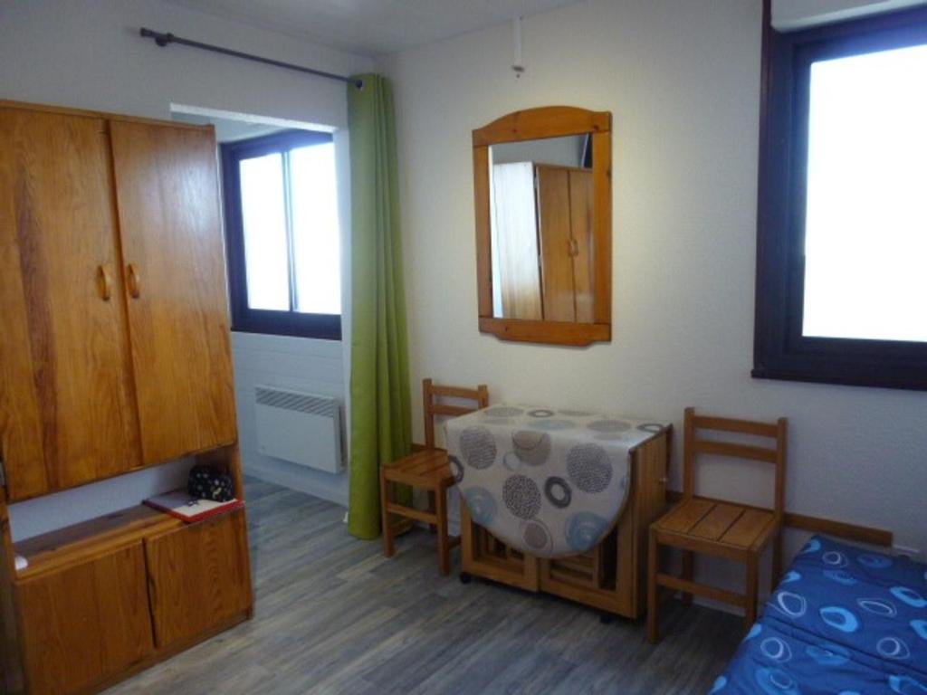 una stanza con un tavolo, sedie e uno specchio di Arette : Apt 4/5 pers, au pied des pistes, ascenseur, parking, micro-ondes/grill - FR-1-602-107 ad Arette