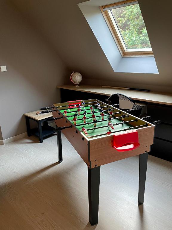 a foosball table in a room with a window at L&#39;écureuil de la Baie - maison en Baie de Somme in Mons-Boubert