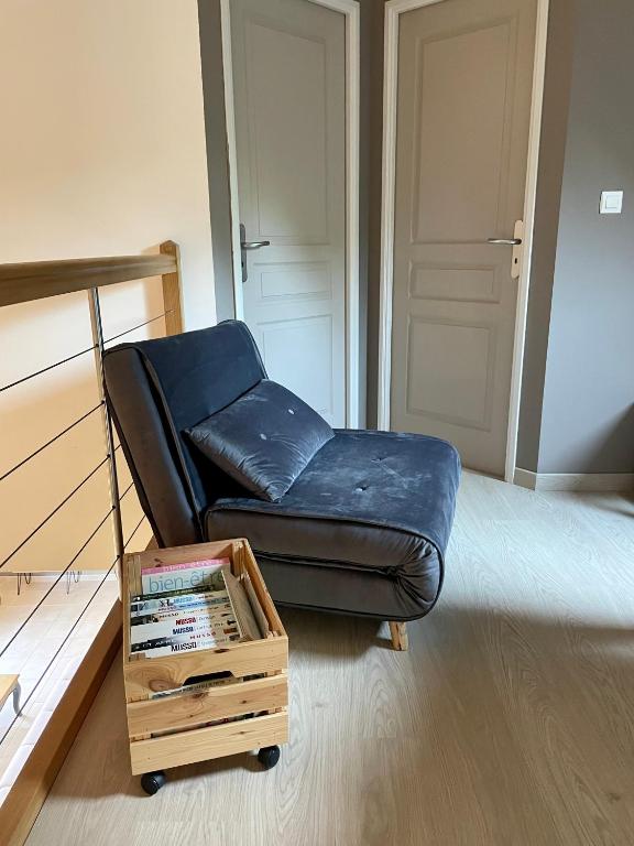 a black leather couch with a wooden coffee table in a room at L&#39;écureuil de la Baie - maison en Baie de Somme in Mons-Boubert