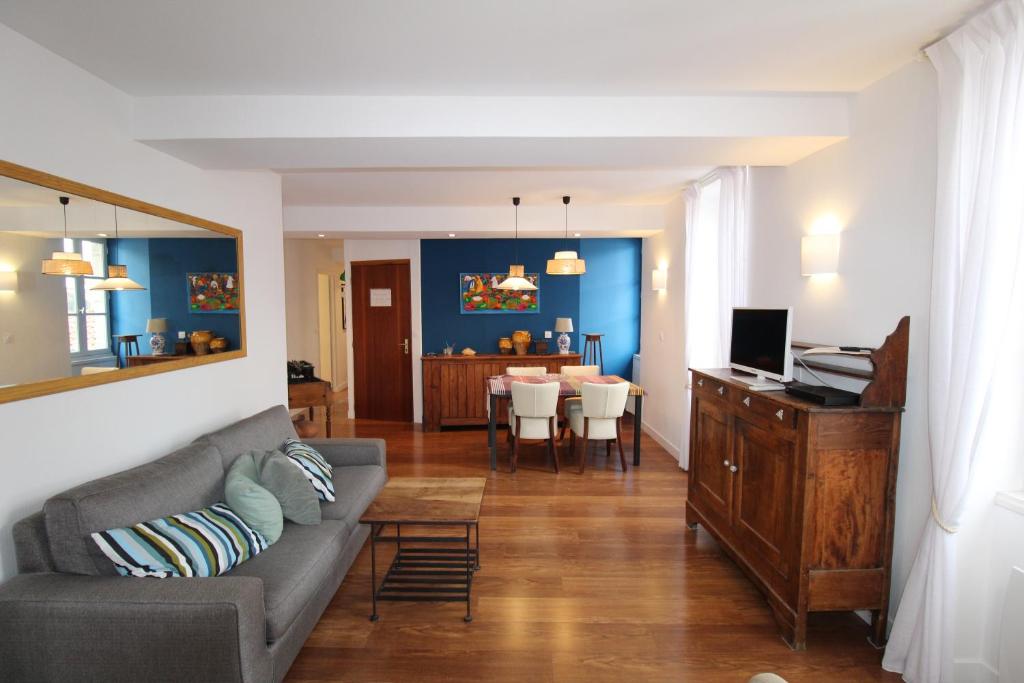 a living room with a couch and a dining room at RHUNE ET MER AVEC LES CLES DE LUZ in Saint-Jean-de-Luz