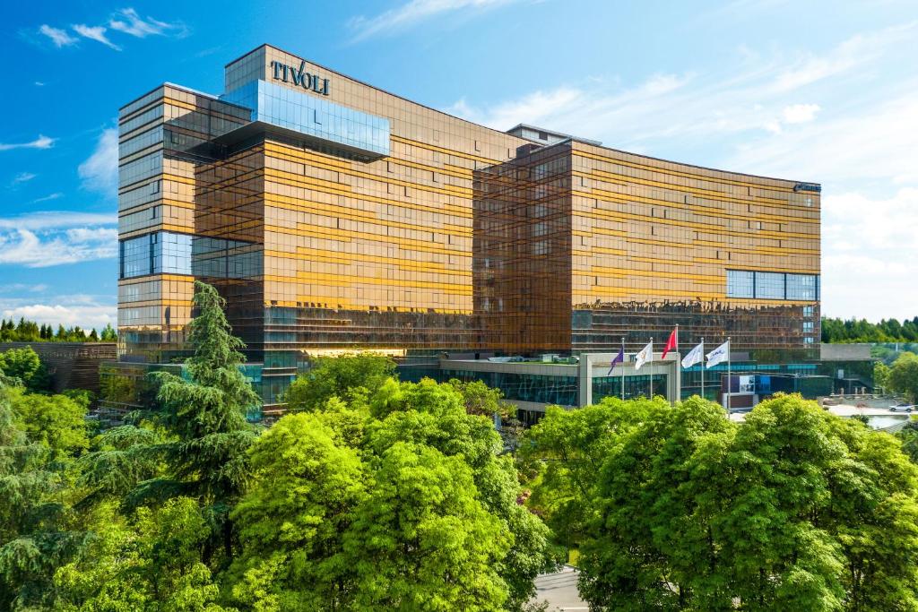 a hotel building with trees in front of it at Tivoli at Cultural Heritage Park in Chengdu