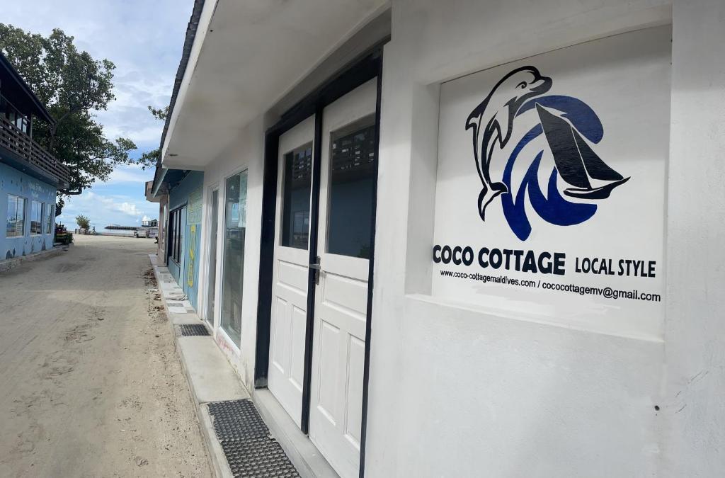 a sign on the side of a building at Coco Cottage Local Style in Guraidhoo