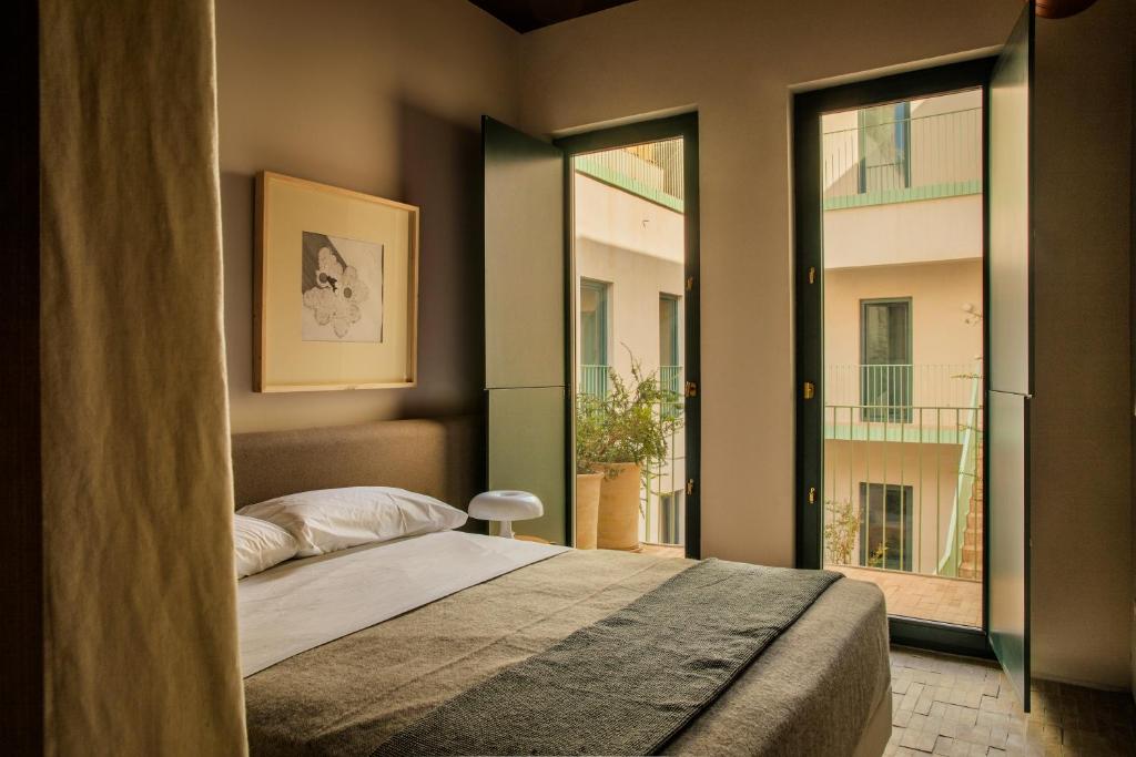 1 dormitorio con cama y ventana grande en BOS*COS APARTMENTS, en Sevilla