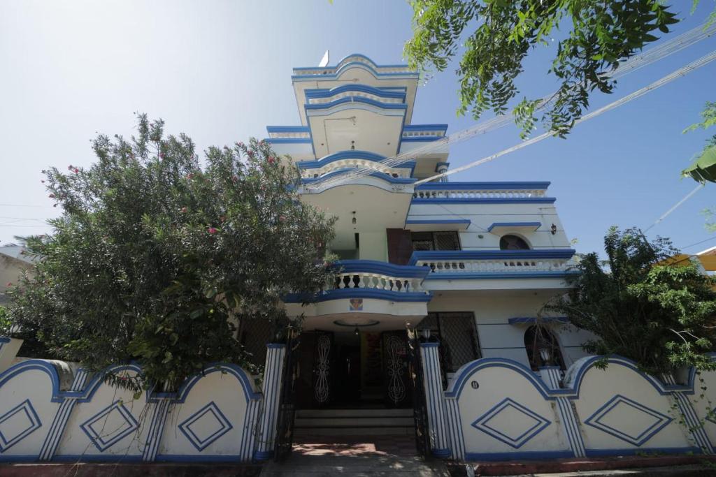 a blue and white house with a gate and trees at Karthik residence in Puducherry