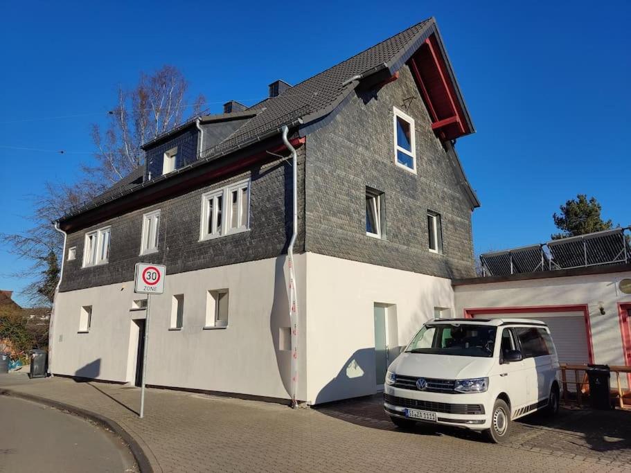 una furgoneta blanca estacionada frente a una casa en Kinderklinik, 600m zum Bahnhof 2B, en Siegen