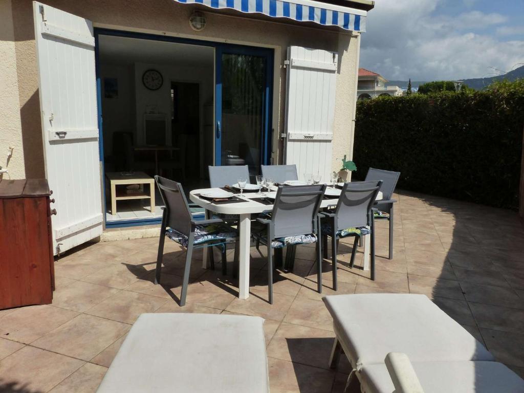 une table et des chaises assises sur une terrasse dans l'établissement Mazet Climatisé 3P avec Terrasse et Piscine - Le Lavandou - FR-1-308-78, au Lavandou