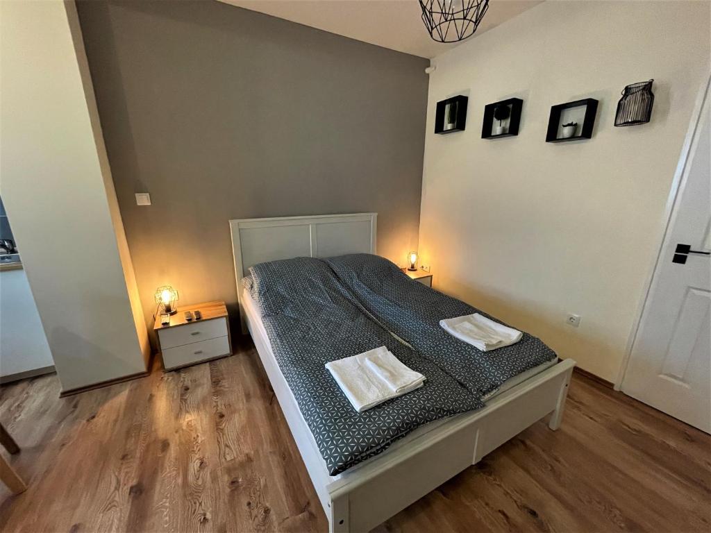 - une chambre avec un lit et 2 serviettes dans l'établissement Hanna Apartman, à Debrecen