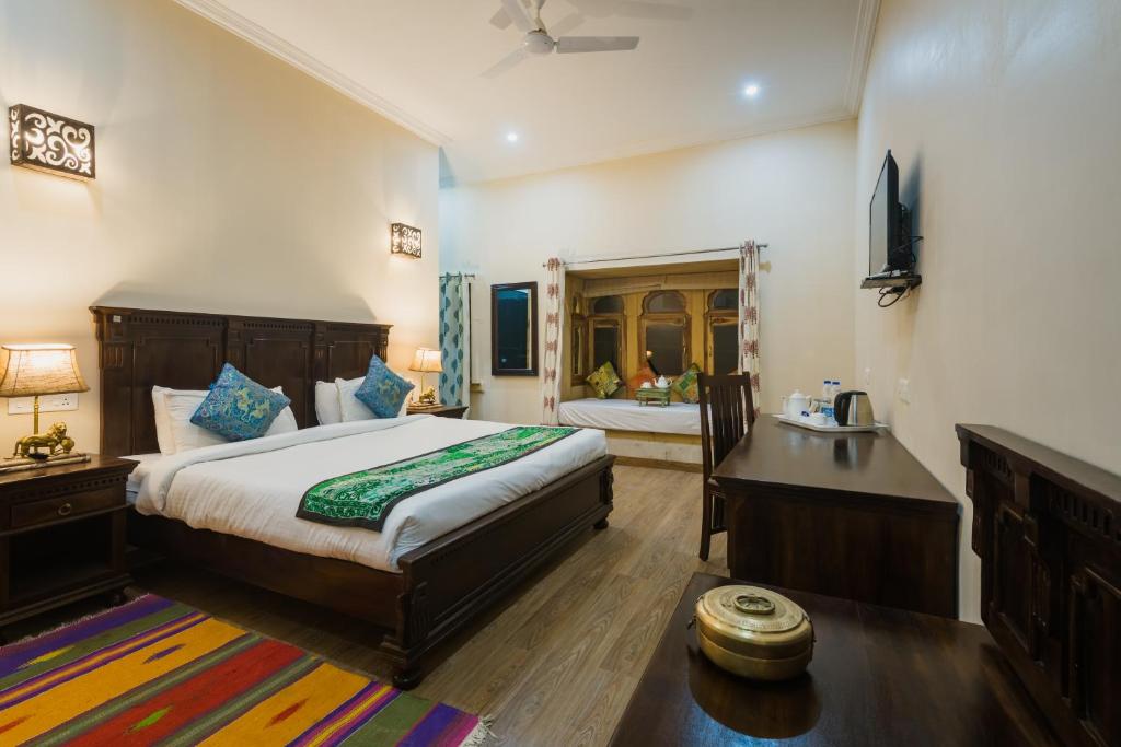 a bedroom with a large bed and a bathroom at Dev Garh in Jaisalmer