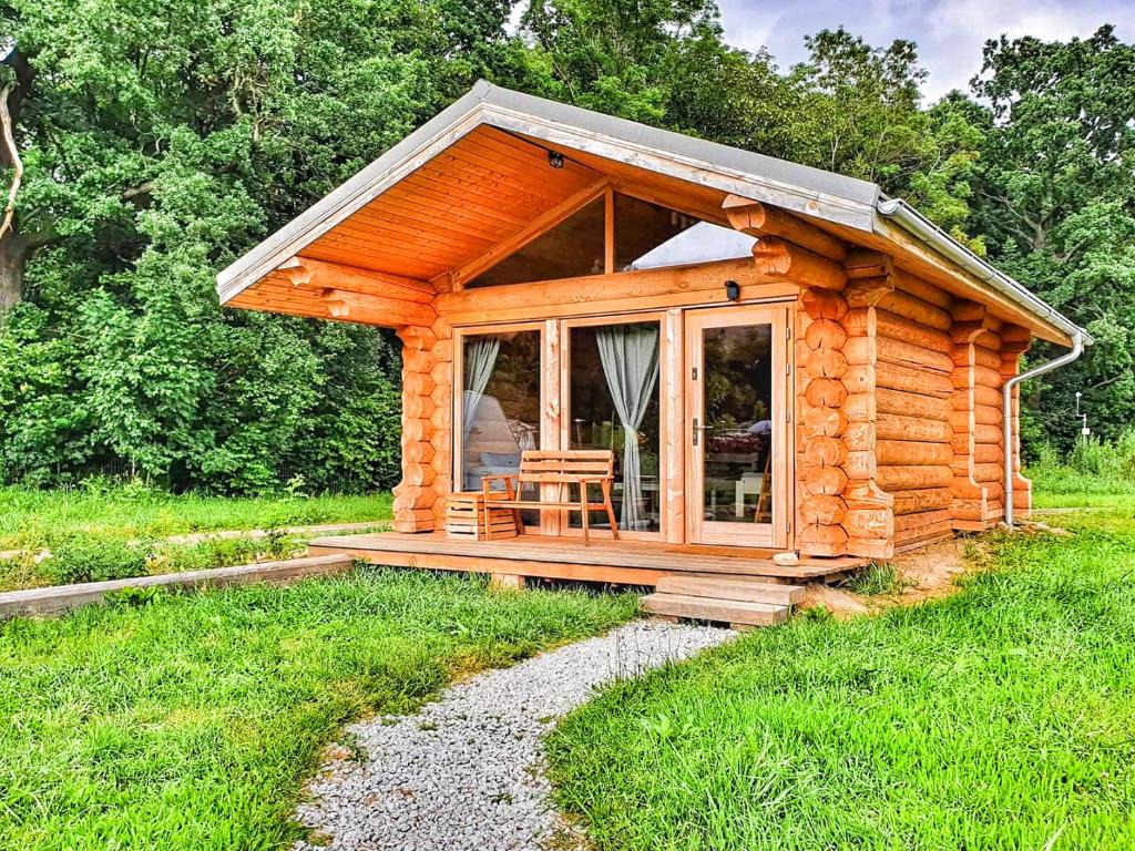 Cabaña de madera con porche y silla en Camp66, en Karpacz