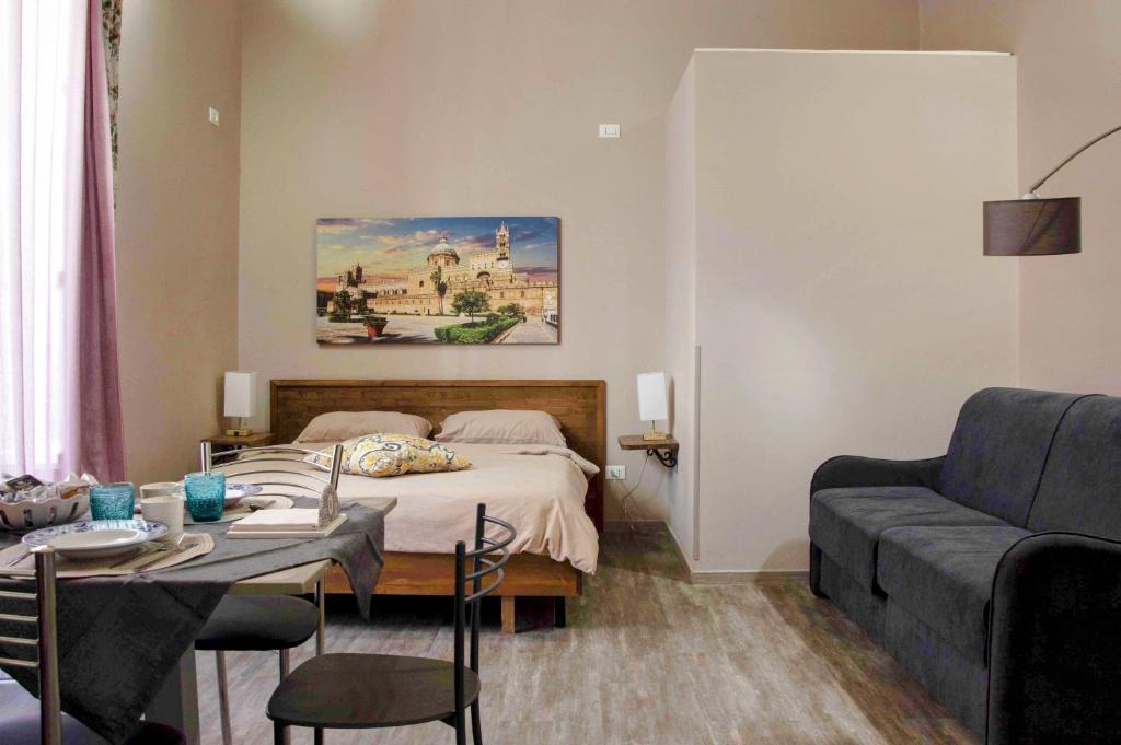 sypialnia z łóżkiem, stołem i kanapą w obiekcie B&B Benincasa w mieście Palermo