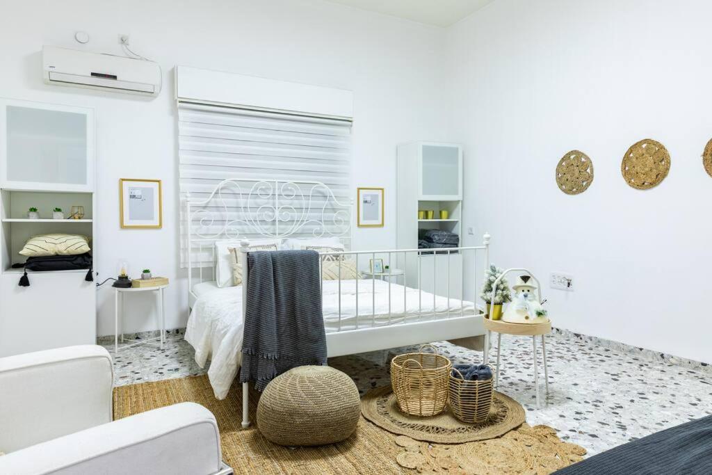 a white bedroom with a bed and a table at Luxury House since 1960 in Nazareth