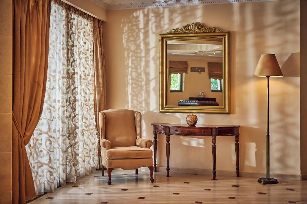 een kamer met een bureau, een spiegel en een stoel bij Palazetto Suites Zakynthos - Adults Only in Tsilivi