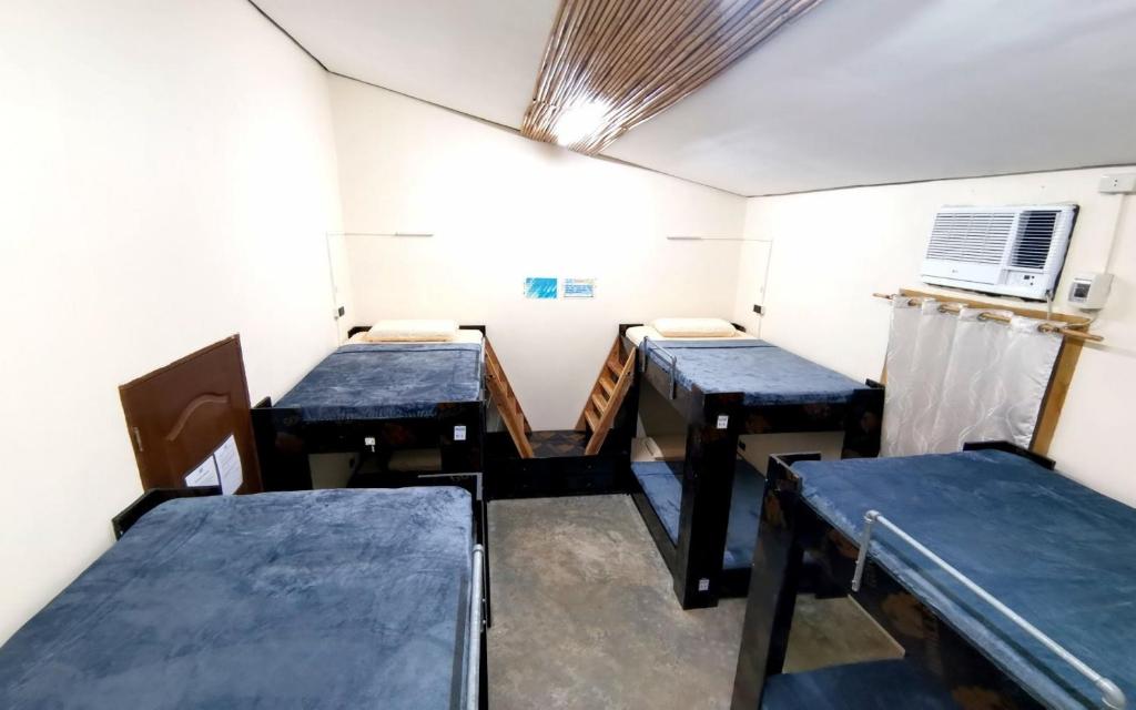 a room with three tables in a room at Big Paul Hostel in El Nido
