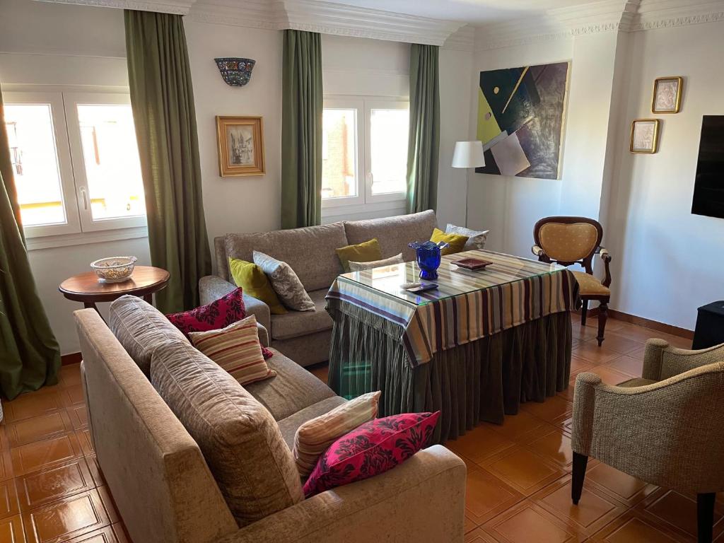 - un salon avec un canapé et une table dans l'établissement Apartamento Ravel Playa Málaga, à Malaga