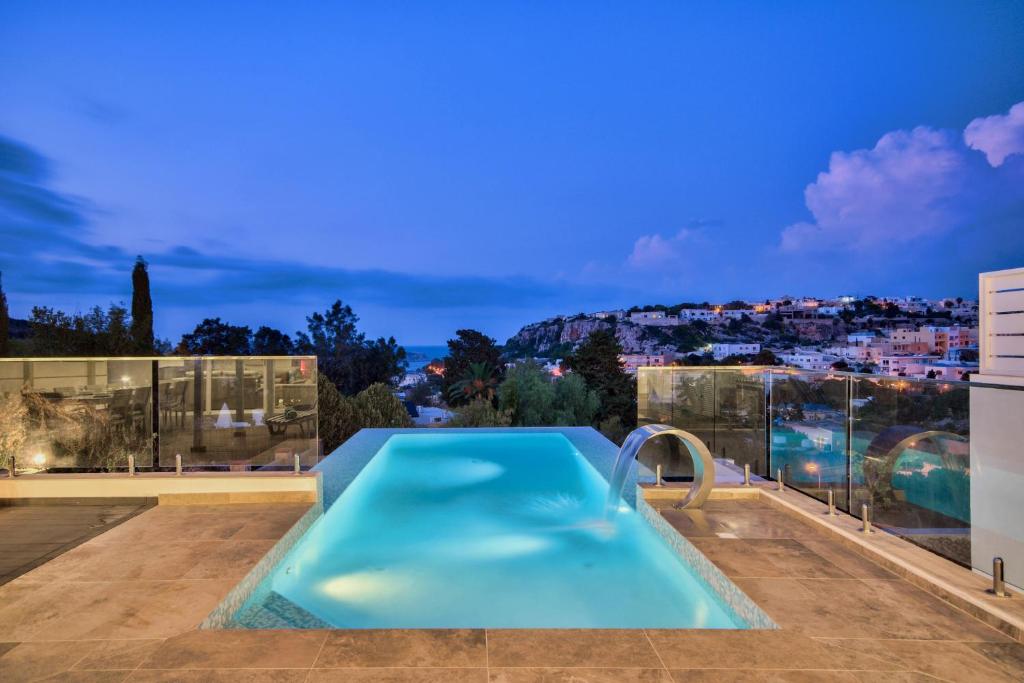 a swimming pool on the roof of a house at Maltese Luxury Villas - Sunset Infinity Pools, Indoor Heated Pools and More! in Mellieħa