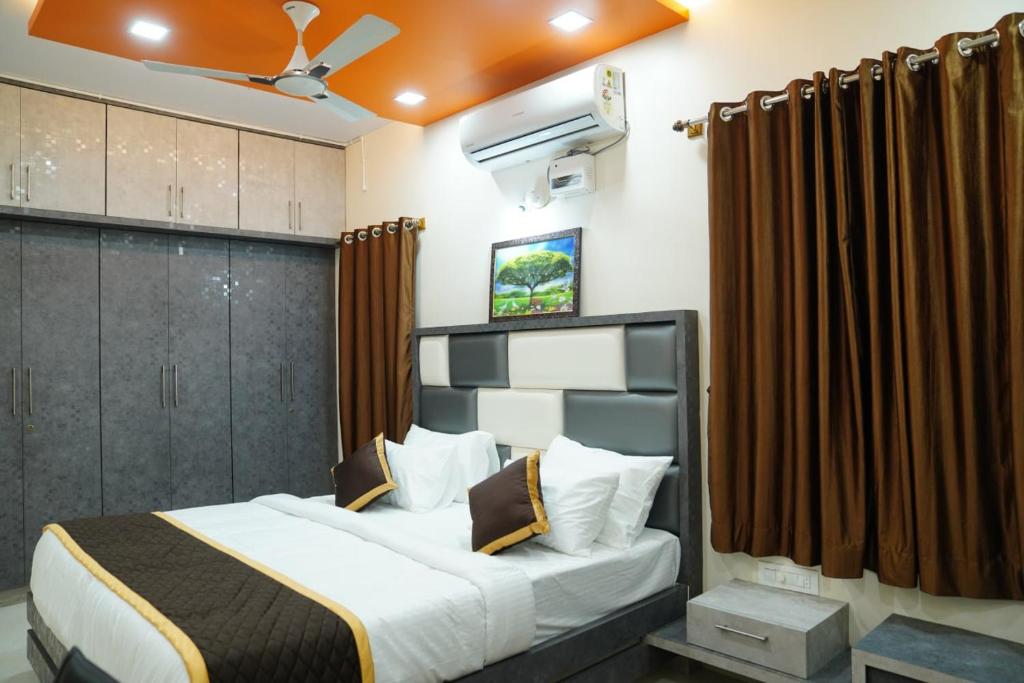 a bedroom with a large bed with brown curtains at Kantesha Nest in Shimoga