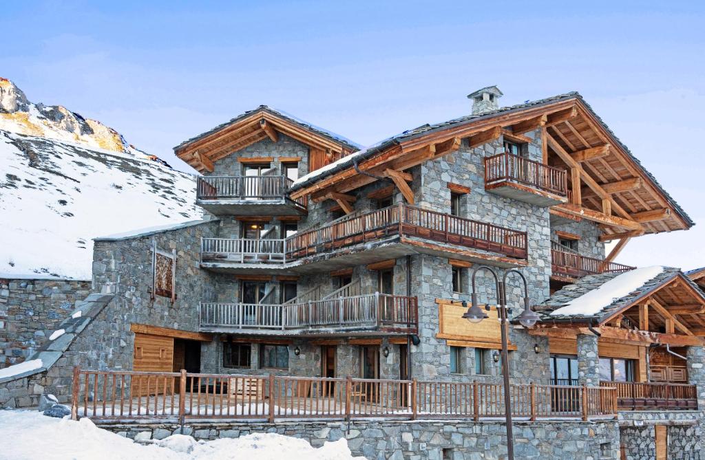 una gran cabaña de madera en las montañas con nieve en Hôtel L'Aigle du Montana by Les Etincelles, en Tignes