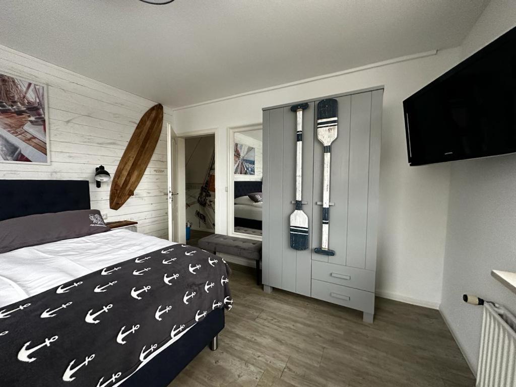 - une chambre avec un lit et une télévision à écran plat dans l'établissement Bootshaus Appartements, à Cuxhaven