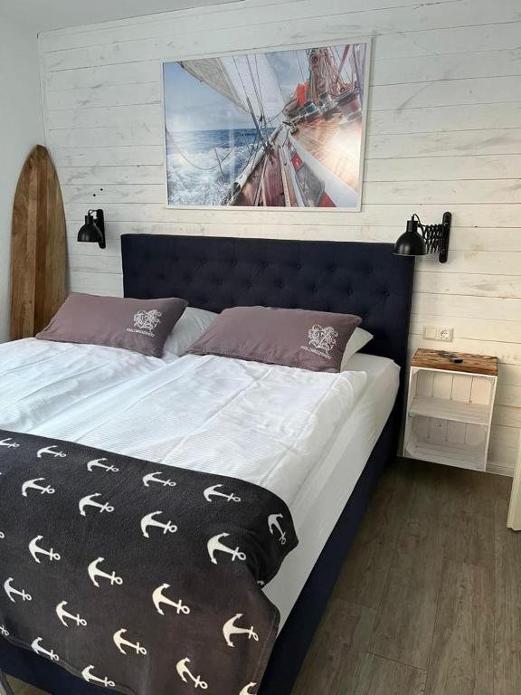 a bedroom with a bed with a black and white comforter at Bootshaus Appartements in Cuxhaven