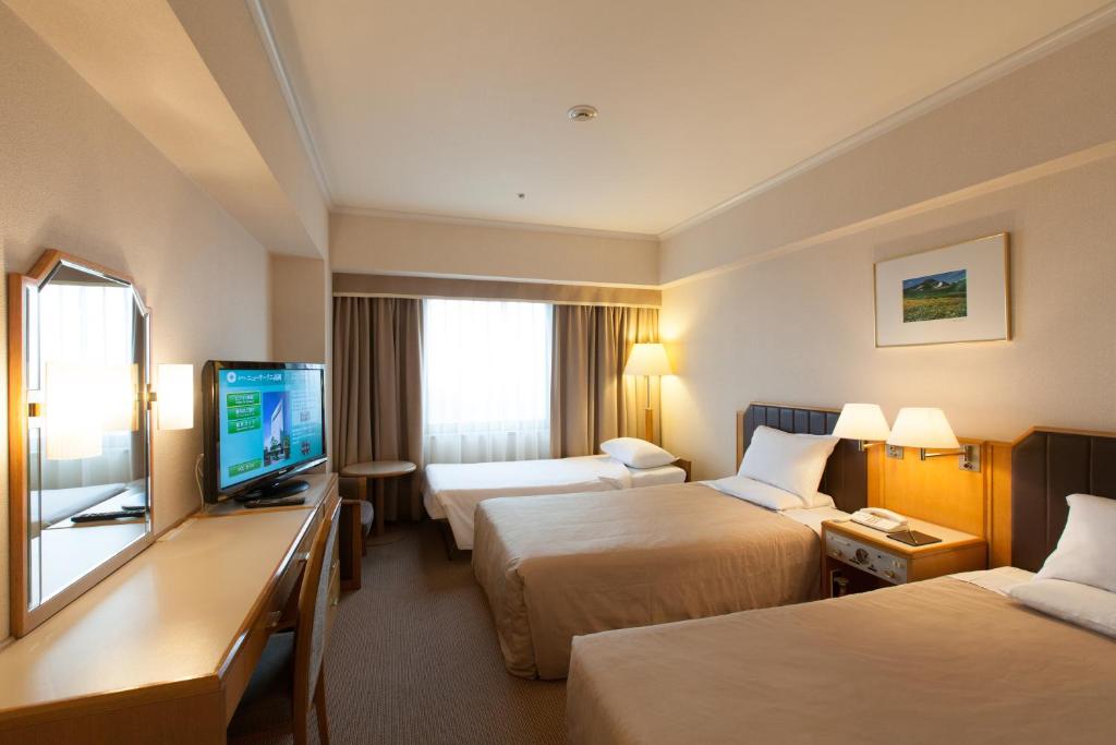 Postel nebo postele na pokoji v ubytování Hotel New Otani Takaoka