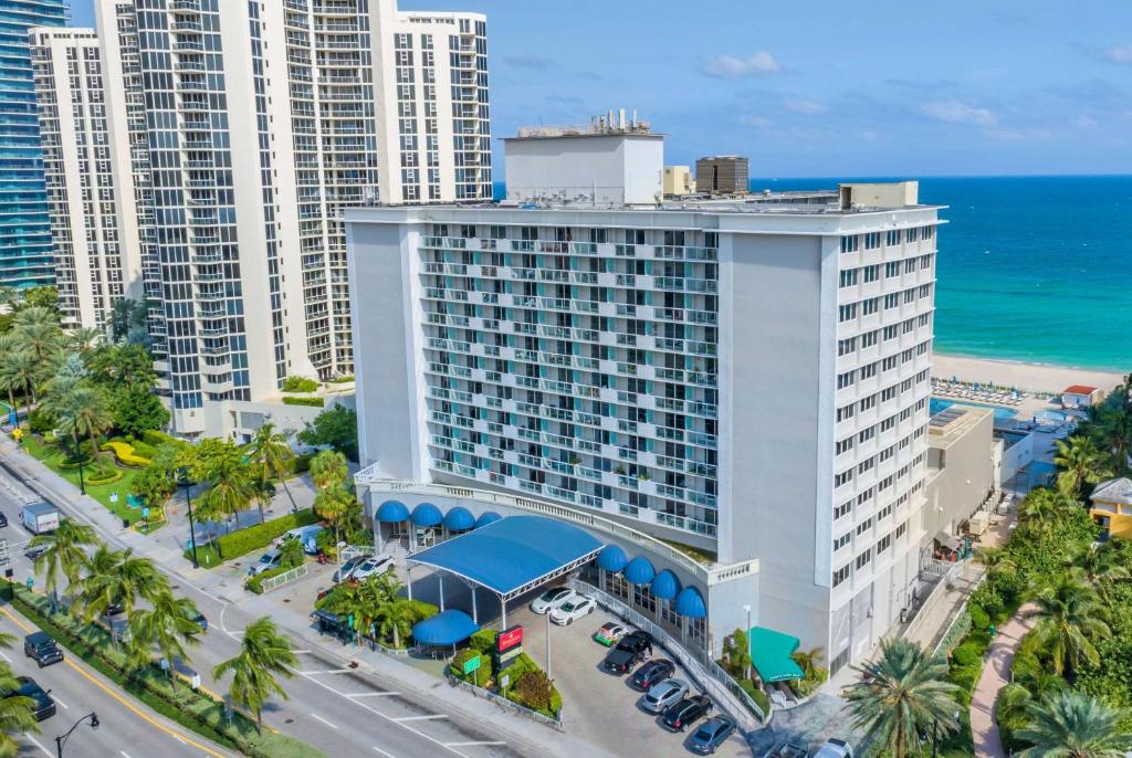 an aerial view of a large white building with the ocean at Ramada Plaza by Wyndham Marco Polo Beach Resort in Miami Beach