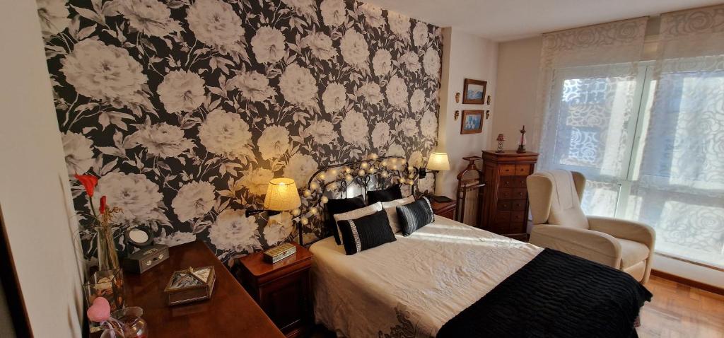 um quarto com uma cama com papel de parede floral em Casa Anabel - Con garaje, 3 hab, 2 baños em Gijón