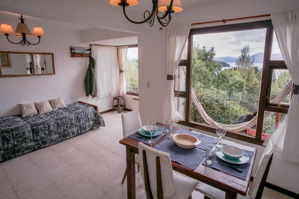 una sala de estar con mesa y una habitación con sofá en Cabaña Viva Patagonia en San Carlos de Bariloche