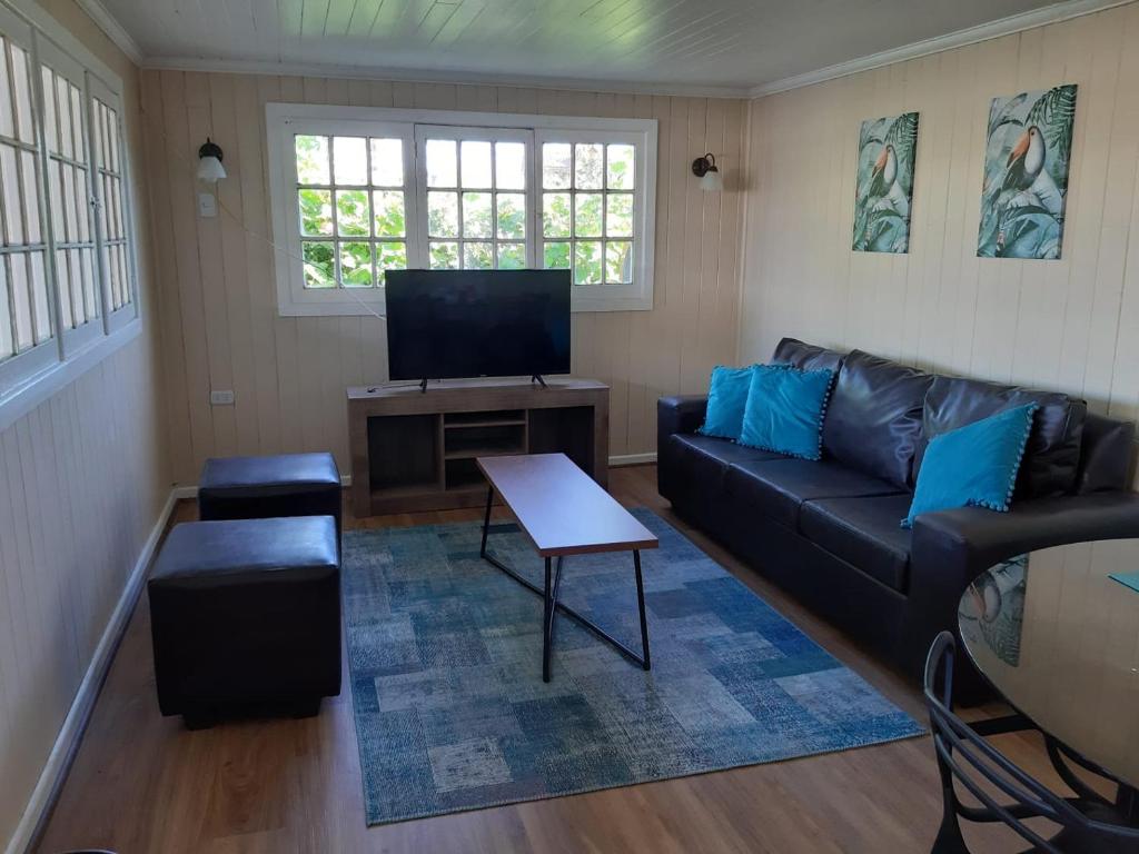 un salon avec un canapé et une télévision dans l'établissement Casa Santa María, à Pichilemu