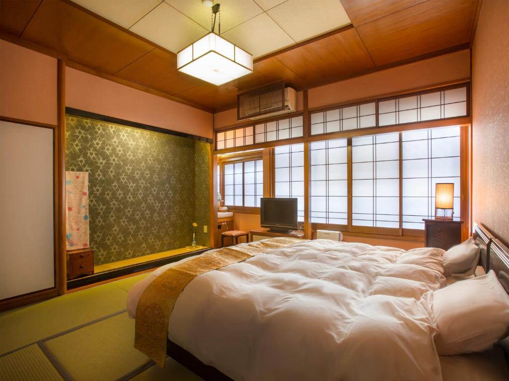 Postel nebo postele na pokoji v ubytování Kinosaki Onsen Hanakouji Saigetsu