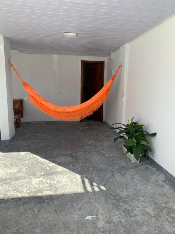 an orange hammock in a room with a plant at Studio Tranquilo in Florianópolis