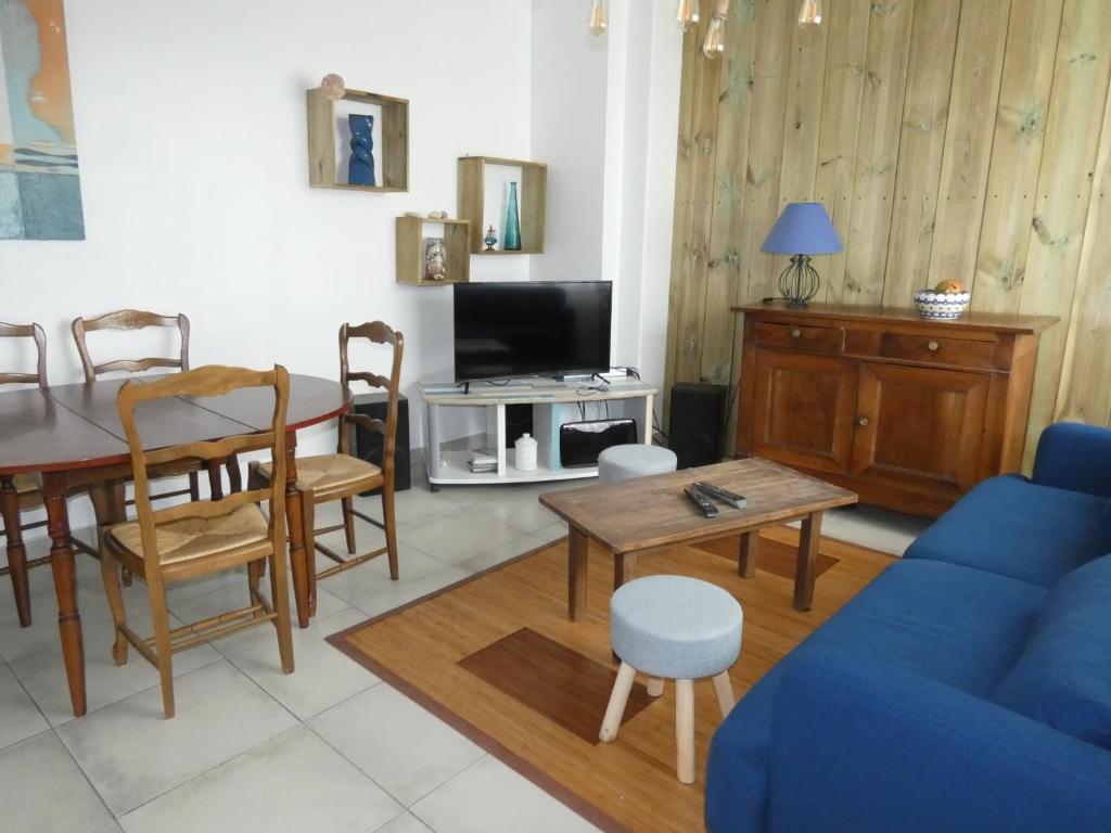 un salon avec un canapé bleu et une table dans l'établissement Appartement T3 avec terrasses et parking privé en centre-ville de Royan, à 200m de la plage - FR-1-71-90, à Royan