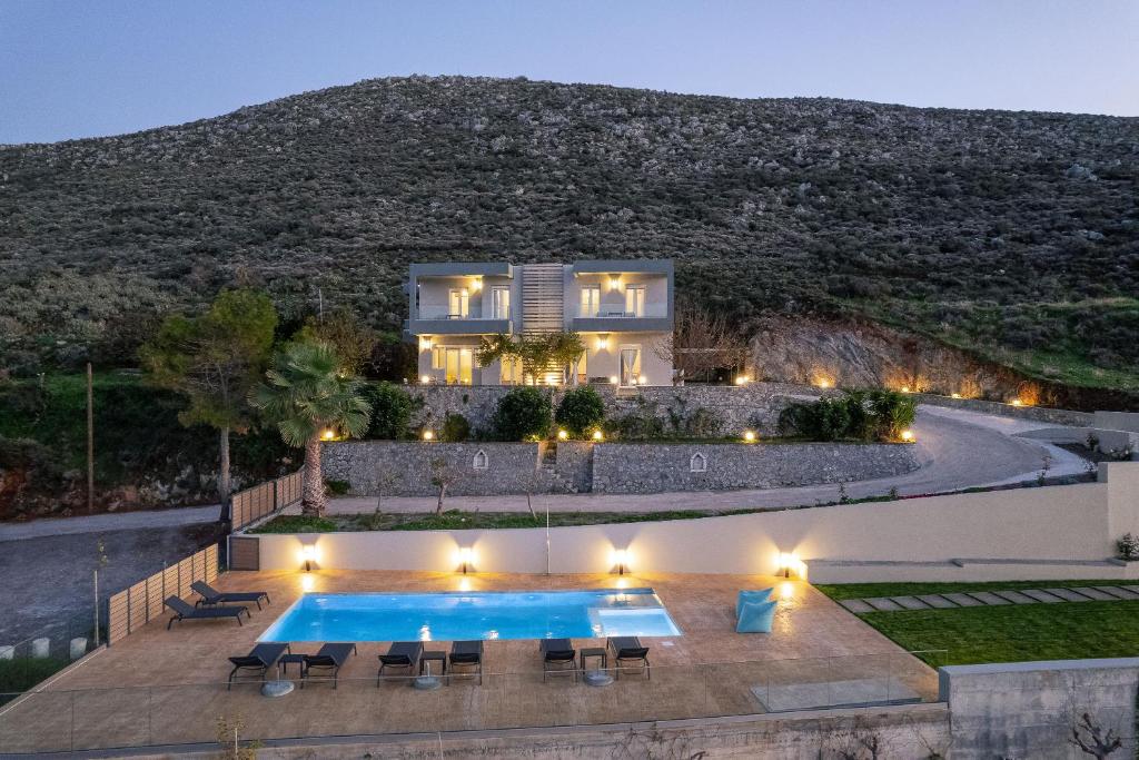 een villa met een zwembad voor een huis bij Pietra Di Mare in Petres