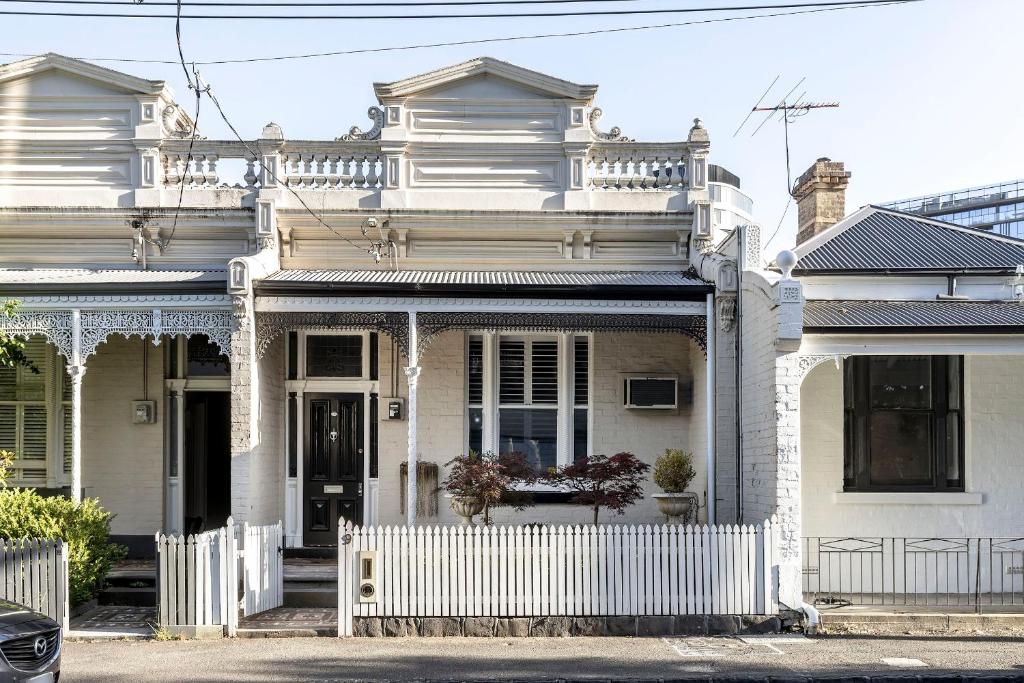 una casa blanca con una valla blanca delante de ella en Circa 1890, en Melbourne