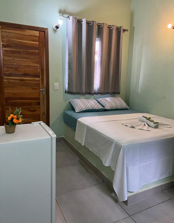 1 dormitorio con 1 cama con lavabo y ventana en Pousada Certa Express, en Chapada dos Guimarães