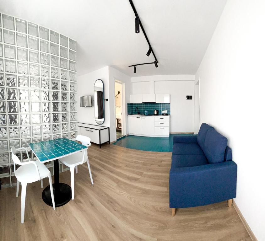 a living room with a blue couch and a table at Kazbegi Apartments in Kazbegi