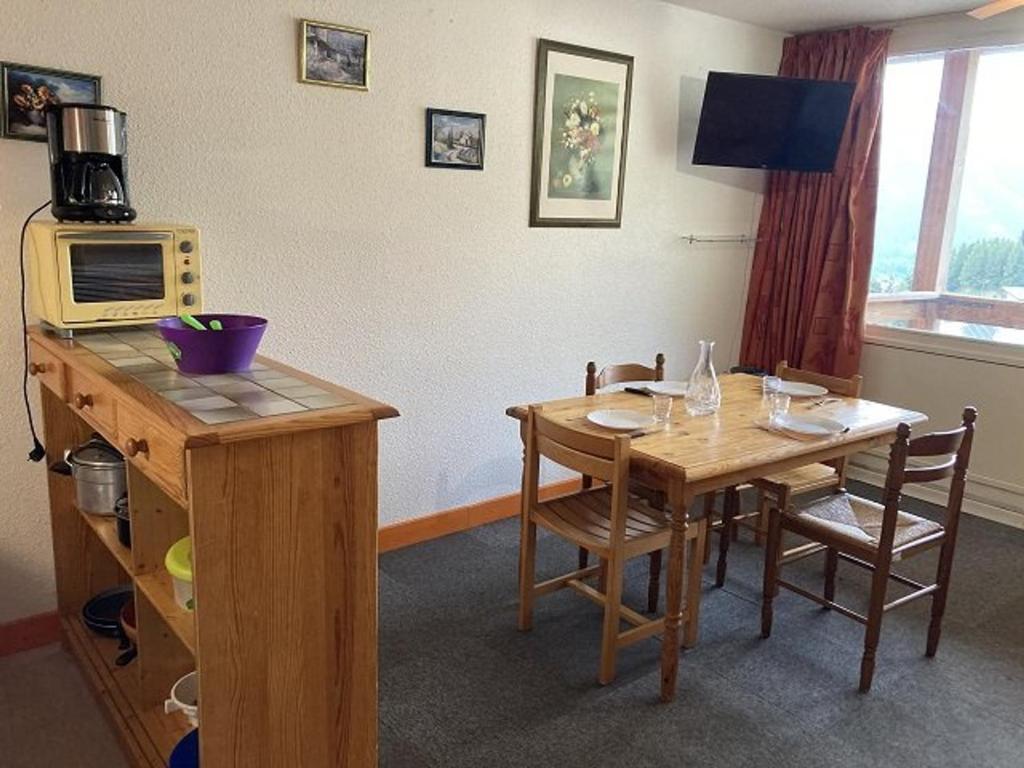 une salle à manger avec une table et un four micro-ondes dans l'établissement Studio lumineux 4 pers, pieds des pistes, balcon sud, proche sports et commerces - FR-1-262-171, à Orcières