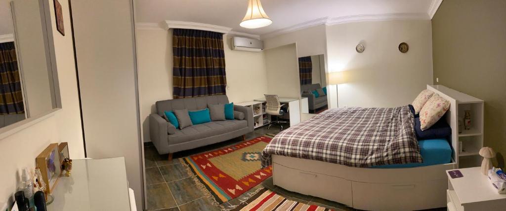 sala de estar con cama y sofá en Cozy in Giza 2 bedroom apartment en El Cairo