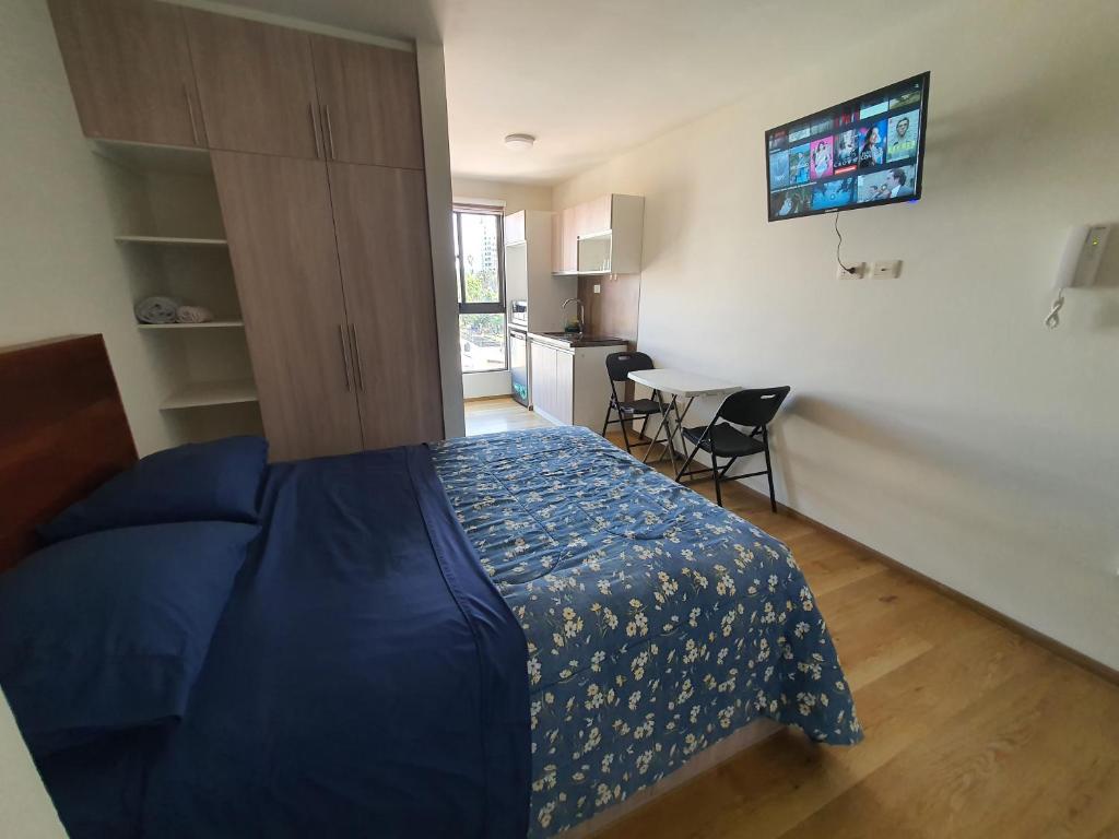 Cet appartement comprend une chambre avec un lit et une cuisine avec une table. dans l'établissement Céntrico monoambiente en el prado, à Cochabamba