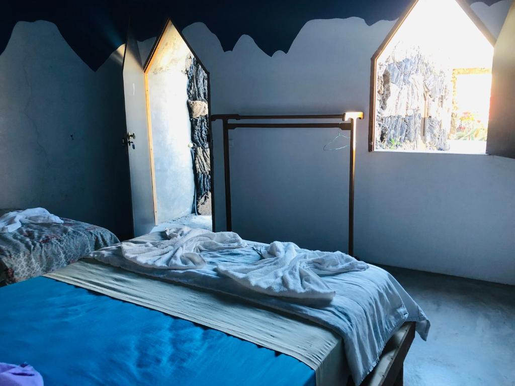 um quarto com uma cama com uma parede azul em Pensão Repouso Alegre Turismo e Aventura em Portela