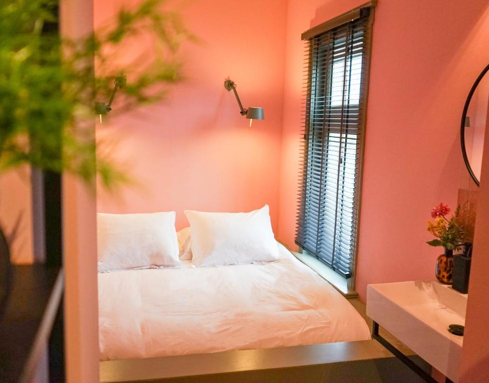 a bedroom with a white bed and a window at Villa la Vida in Tilburg