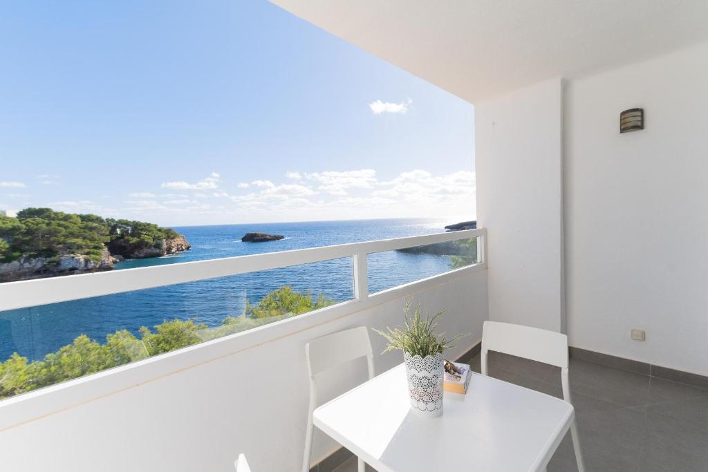 una sala da pranzo bianca con vista sull'oceano di Apartamento Ferrera Park 407 a Cala Ferrera
