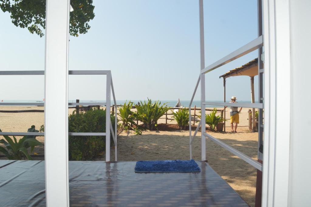 an open door to the beach with a swing at Riya Cottages and Beach Huts in Agonda