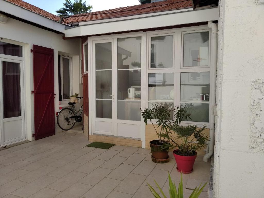 a sliding glass door of a house with plants at Arcachon: Charmante Maison T3 Proche Plage et Commerces, 2 Chambres, Wi-Fi, Idéale Familles - FR-1-319-35 in Arcachon
