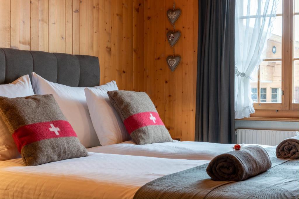 a bedroom with two beds with pillows and a window at Cozy Place in Gstaad center in Gstaad
