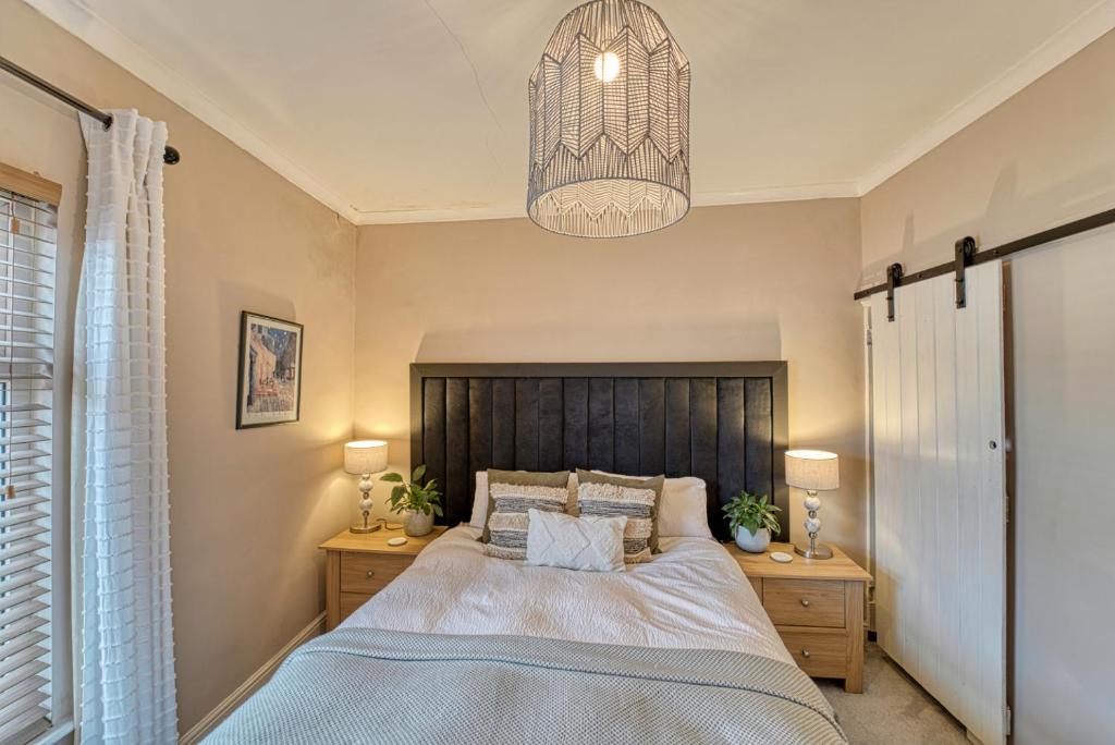 a bedroom with a large bed and a chandelier at Guest Homes - Loughborough Road House in Leicester