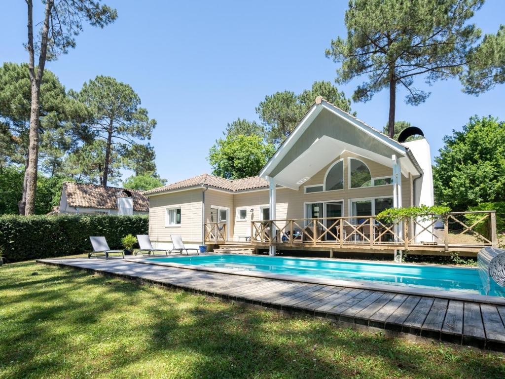 une villa avec piscine et une maison dans l'établissement Villa à Biscarrosse avec piscine chauffée et jardin pour 6 personnes - FR-1-521-93, à Biscarrosse