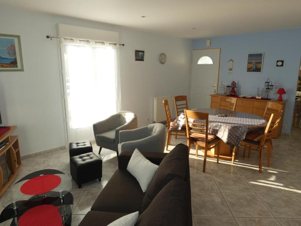 un salon avec un canapé et une table dans l'établissement Maison plain-pied à Saujon, 2 ch, terrasse, jardin, garage, animaux OK, proche Royan et plages - FR-1-71-76, à Saujon